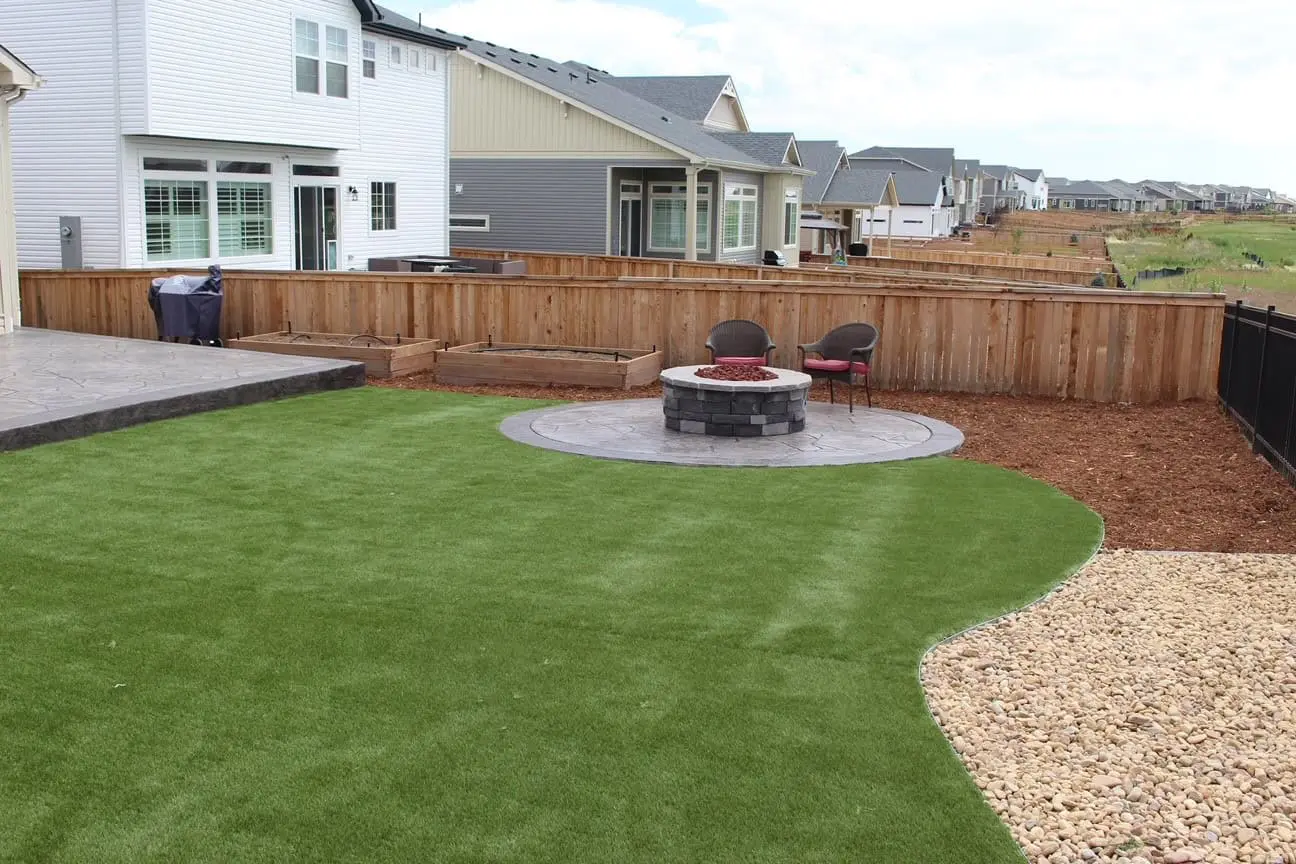 Colorado landscaping with turf, plants, and boulder accents designed for freeze-thaw conditions
