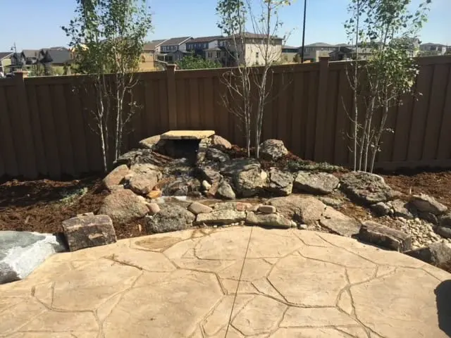 Artificial turf yard with seating and planting by FRSR in Boulder County