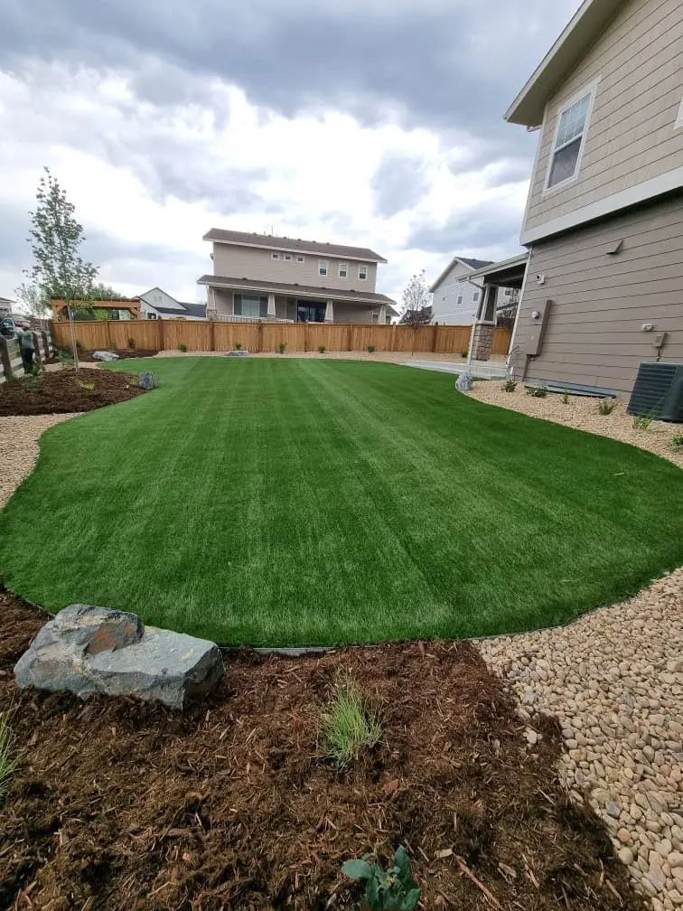 Large Erie backyard with artificial grass and patio space by FRSR