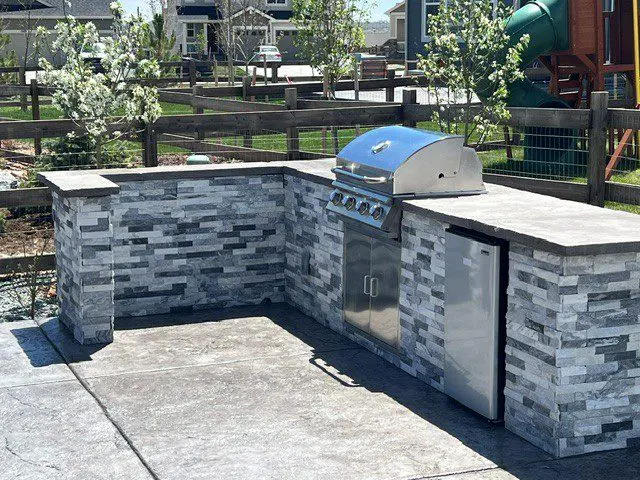 Pollard project in Barefoot Lakes Firestone with stamped concrete patio outdoor kitchen firepit and turf
