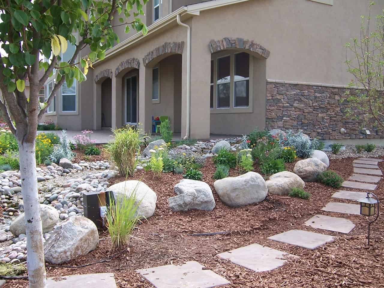Erie backyard with turf, rock and planting by FRSR