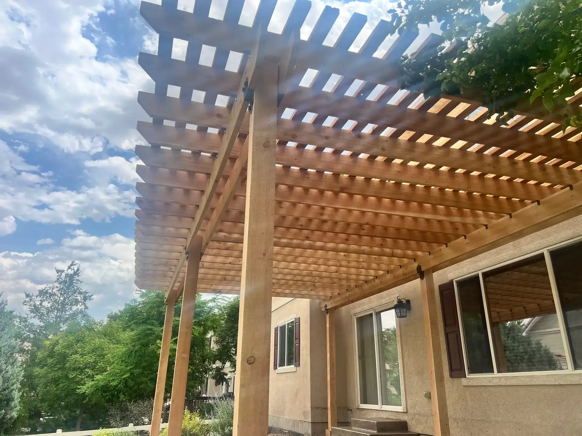 Large pergola over outdoor living space with seating and lighting