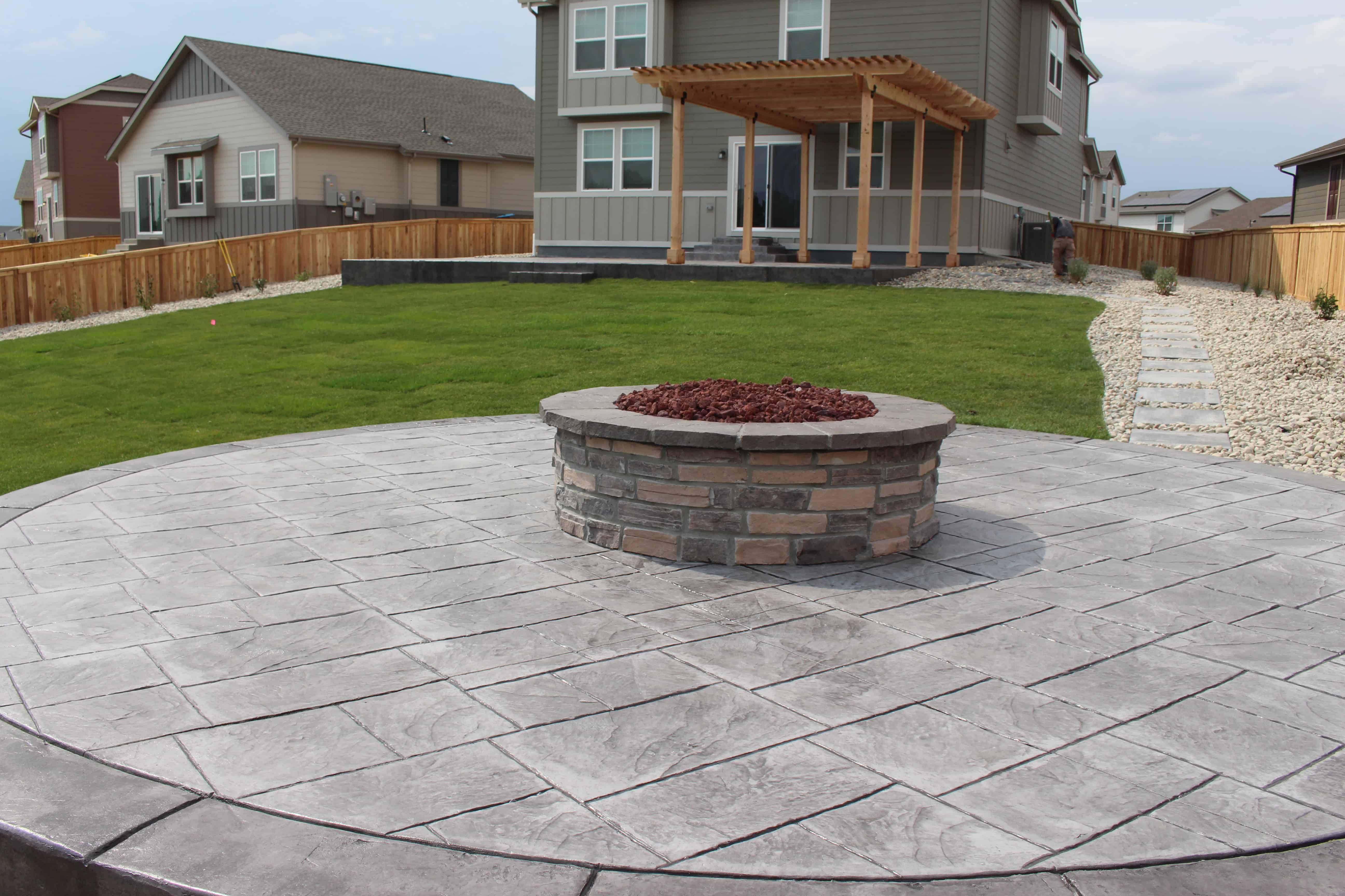 Custom hardscape patio with seat wall and lighting by FRSR