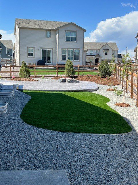 Artificial turf backyard in Parker CO with rock border and clean curve edges