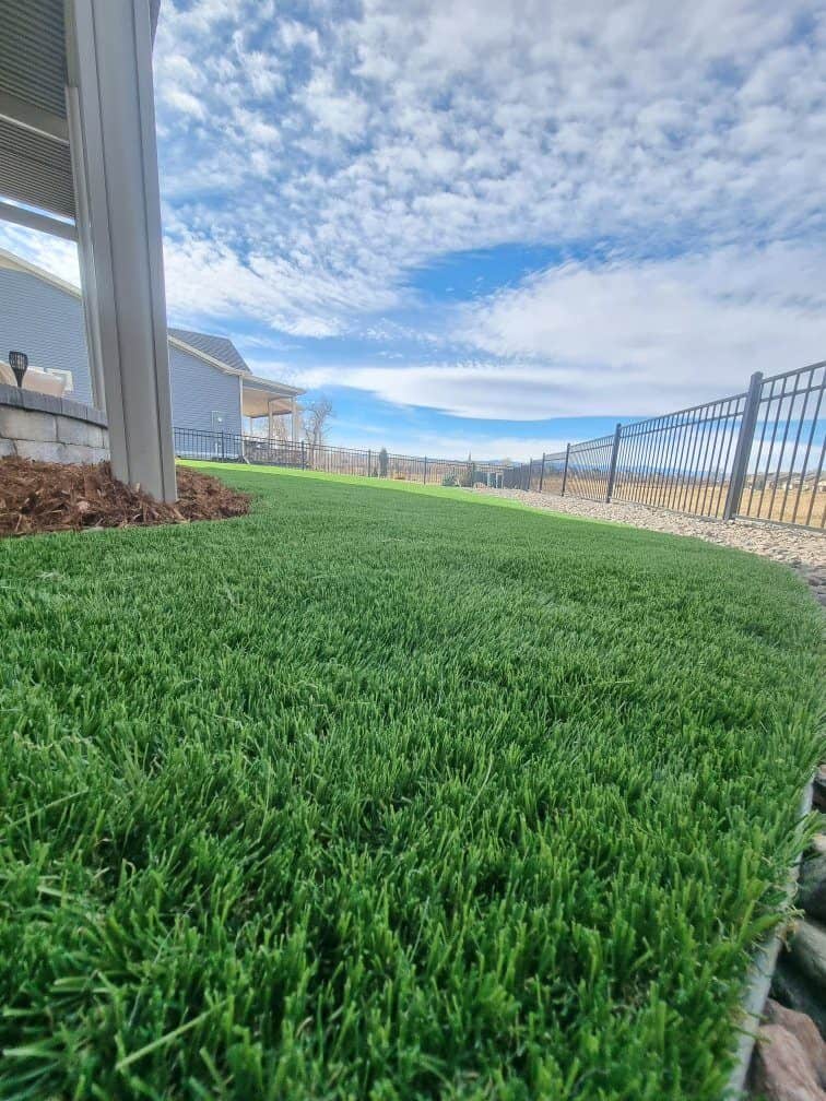 Artificial turf installation with finished edging and decorative landscape border