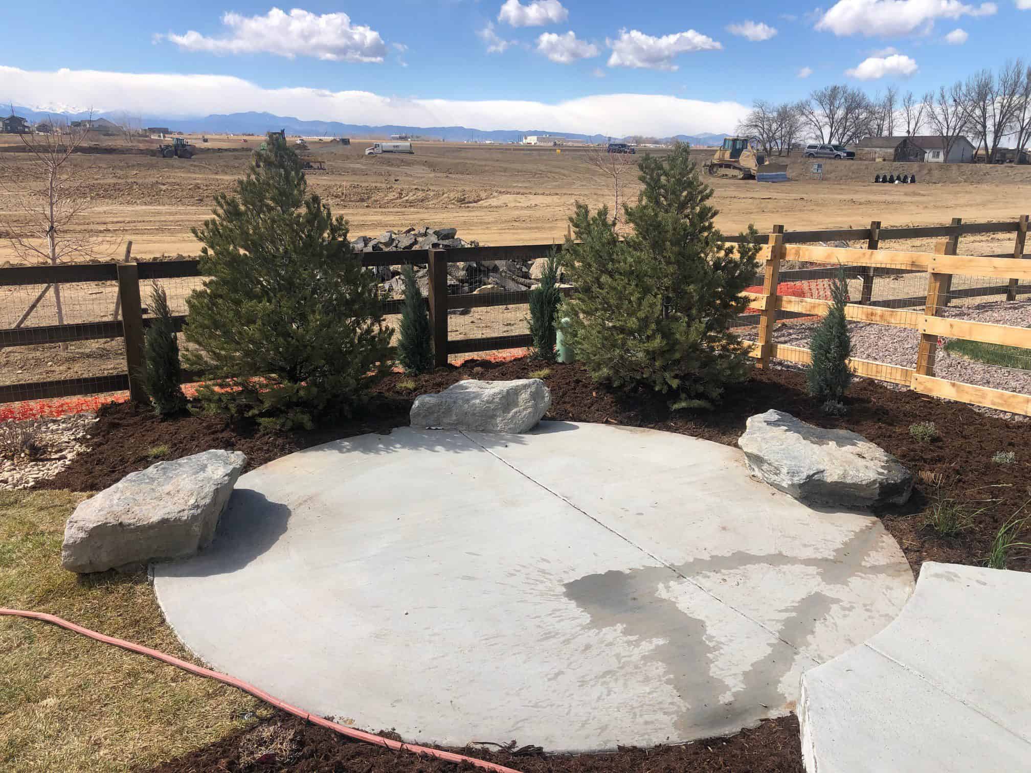 Concrete patio boulders lawn and planting in Barefoot Lakes Firestone