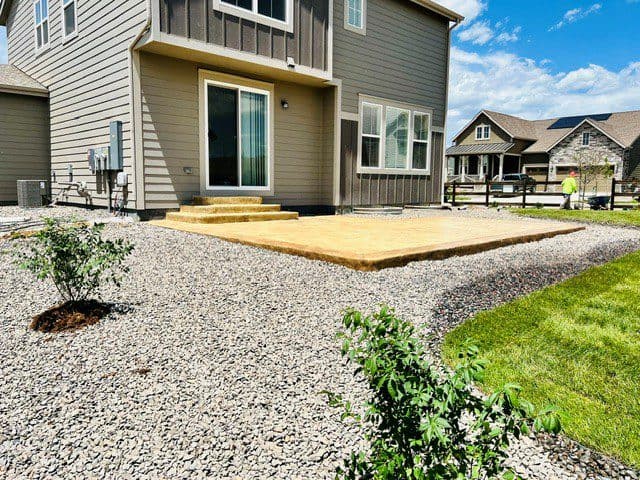 Rockwood project in Barefoot Lakes Firestone with stamped concrete patio berms boulders trees and sod