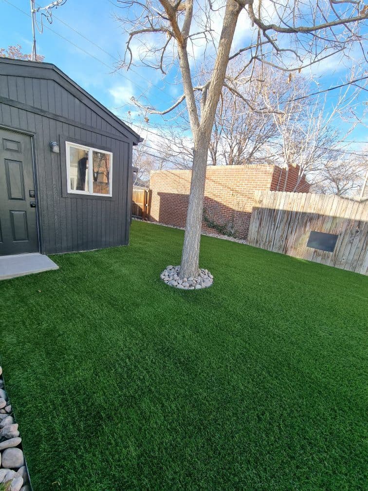 Modern ColoradoScape yard with outdoor living space, boulders, artificial turf, and water-wise landscaping